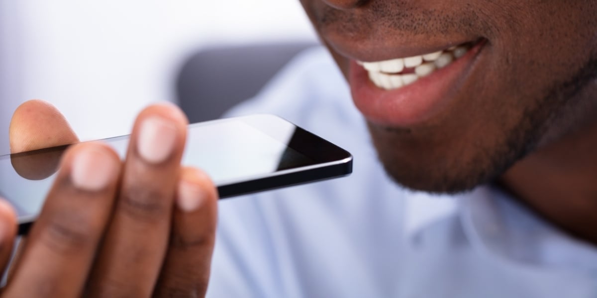 A man using his mobile phone to perform a voice search for business