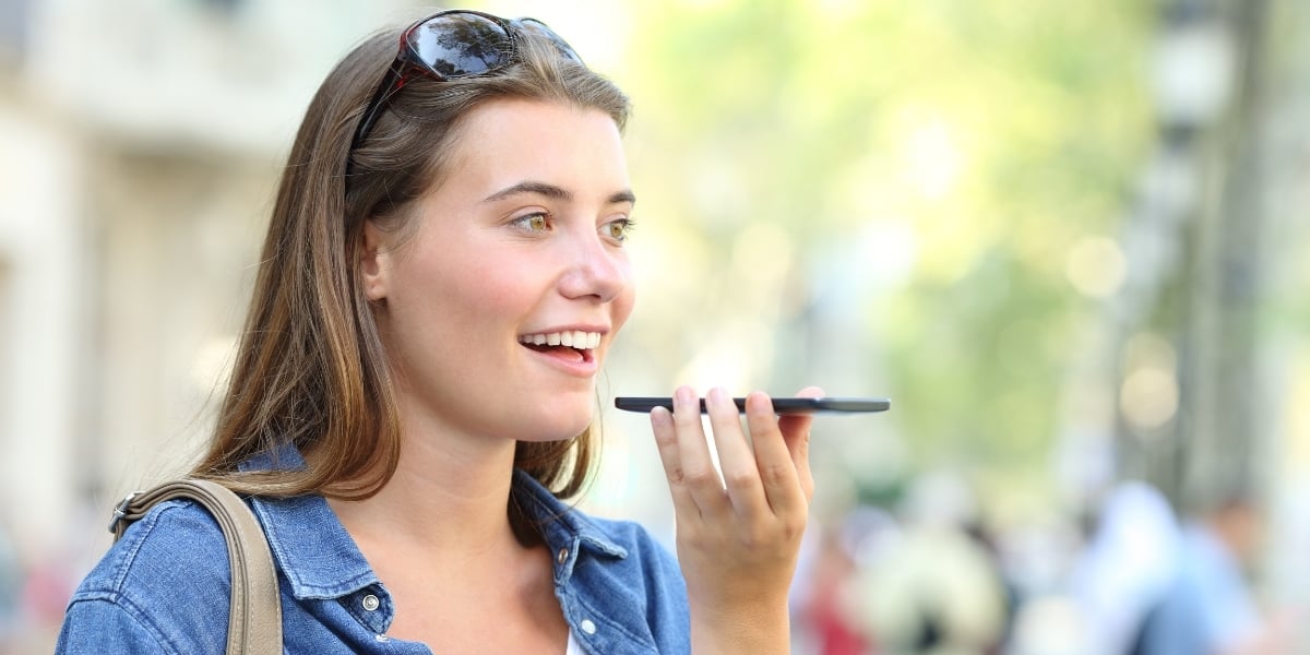 A woman using her mobile device to do a voice search while shopping