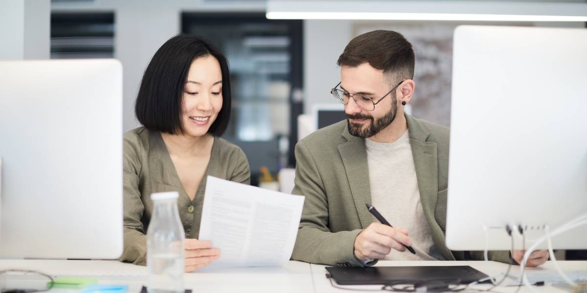 man and woman looking at seo guidelines for small business in 2022 on paper
